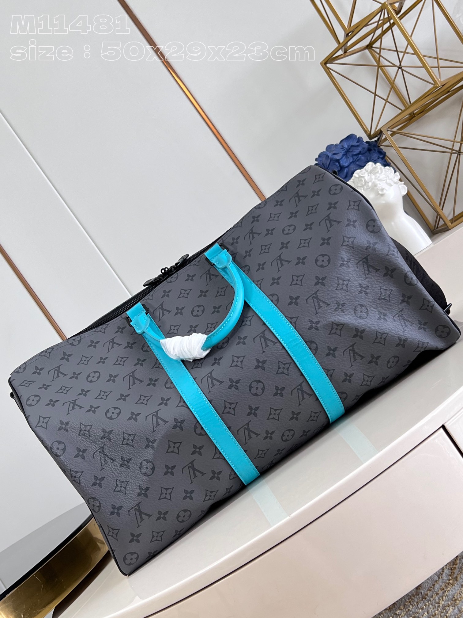 ** Elegancka torba podróżna w grafitowym odcieniu z akcentami błękitu

**